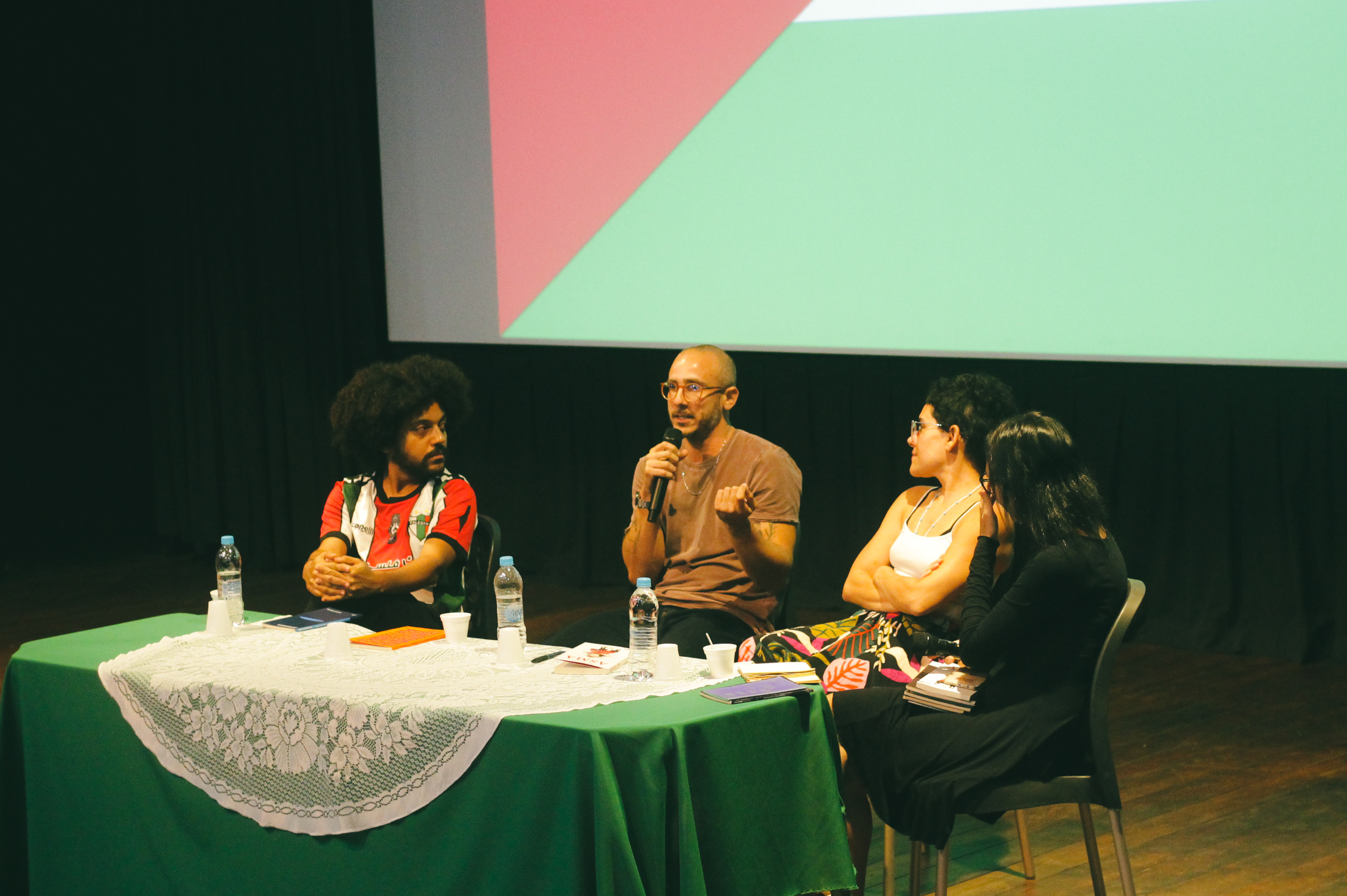 Fotografia. Close em tecido laranja com textura acetinada. O tecido está amassado, formando curvas e sombras suaves.