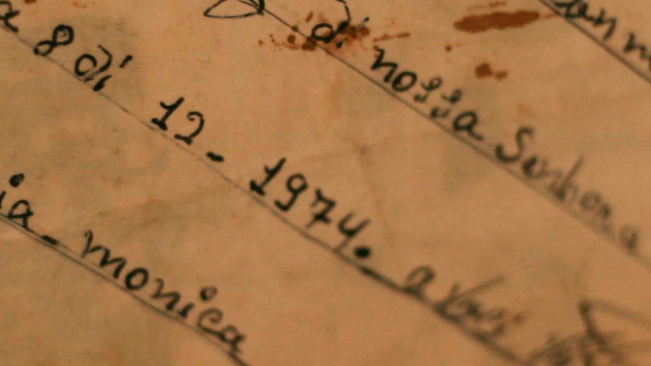 Fotografia. Trecho de carta manuscrita com tinta escura. É possível ler o nome 'Mônica' e a data '8 de dezembro de 1974'.